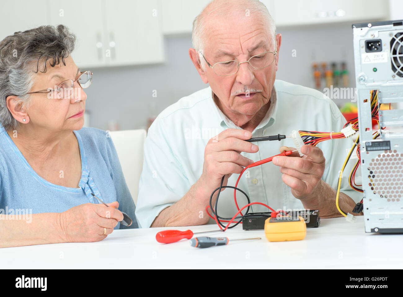 Senior man testing computer with multimeter Stock Photo - Alamy