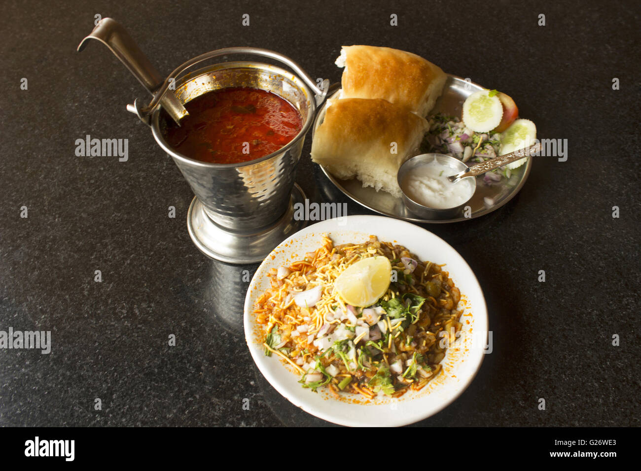 Misal pav. Spicy bean curry and bread topped with potato chiwda mix onions  lemon and coriander (cilantro). Maharashtra India Stock Photo - Alamy