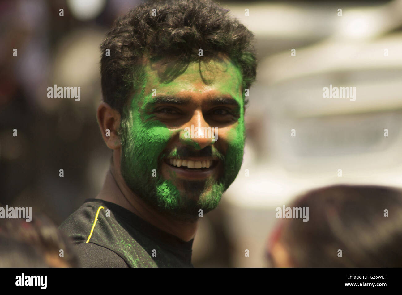 Smiling guy with green face paint. Holi festival Pune Maharashtra India Stock Photo