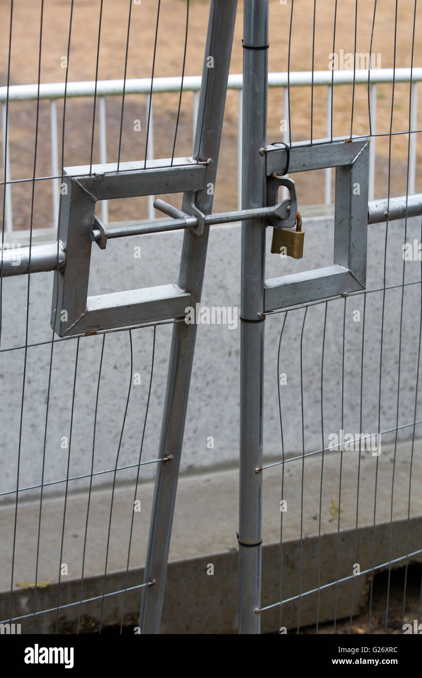 Entrance gate to a building site locked and chained shut. Stock Photo