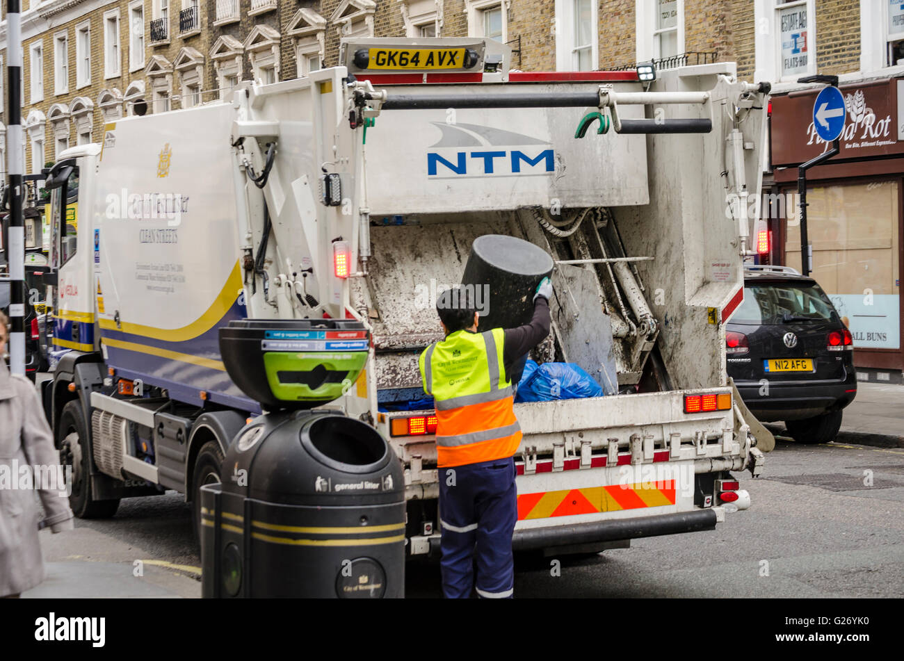Rubbish bins on Queensway in Bayswater, London are emptied into a rubbish truck. Stock Photo