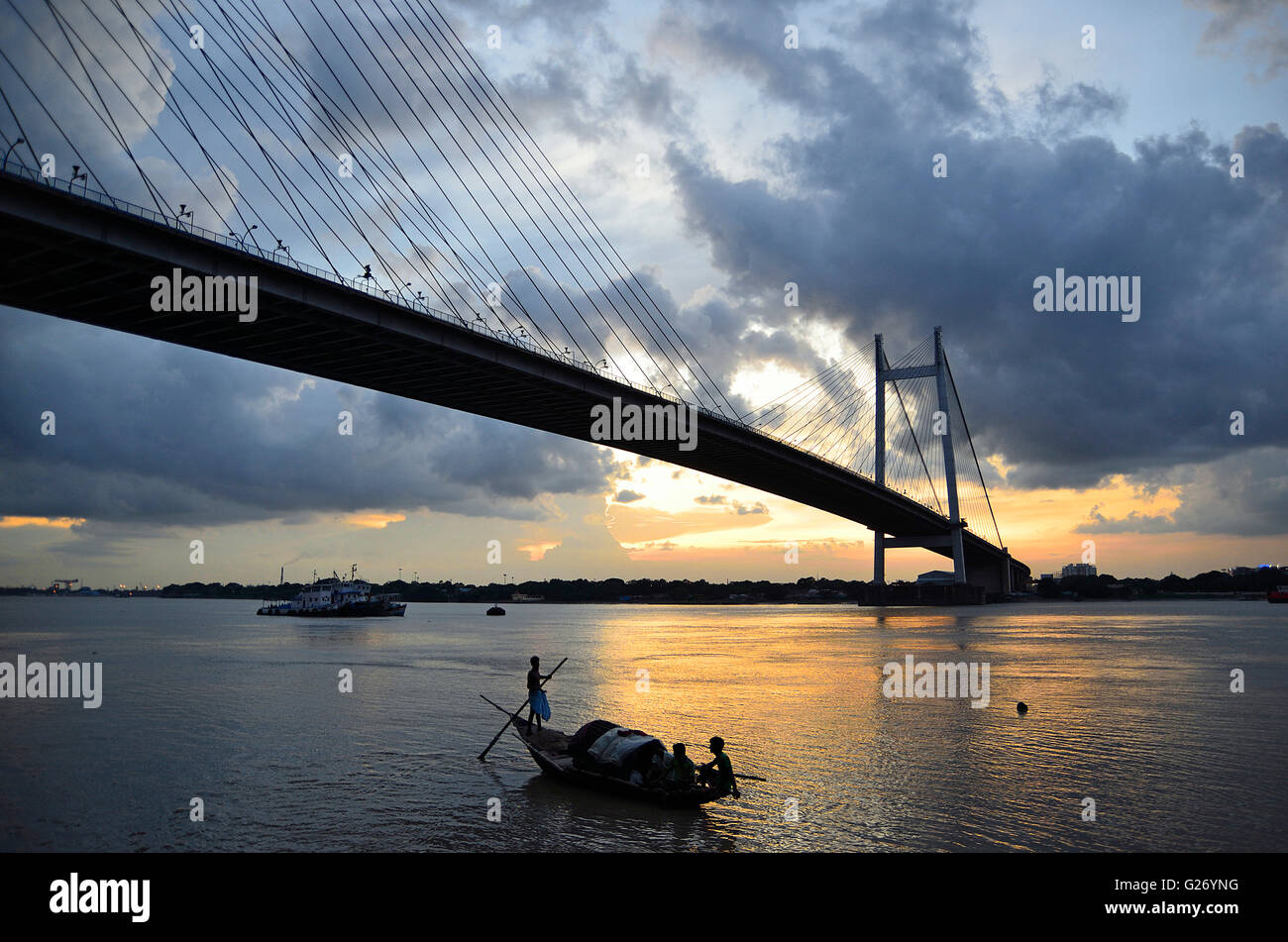 Rain clouds hover over Second Hooghly Bridge at sunset with country fishing  boats float in the river below, Kolkata, West Bengal Stock Photo - Alamy, image size:1300x951