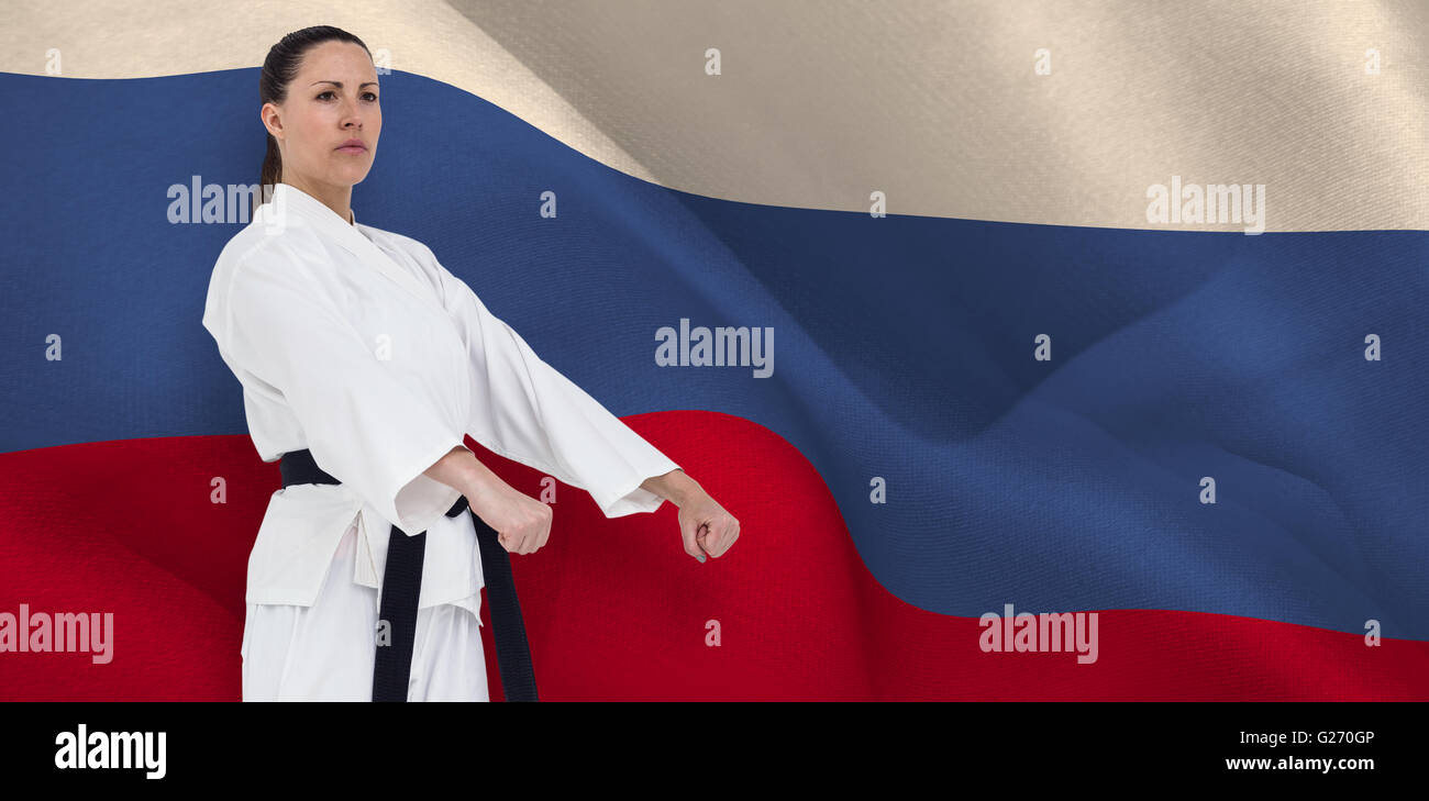 Composite image of female fighter performing karate stance Stock Photo