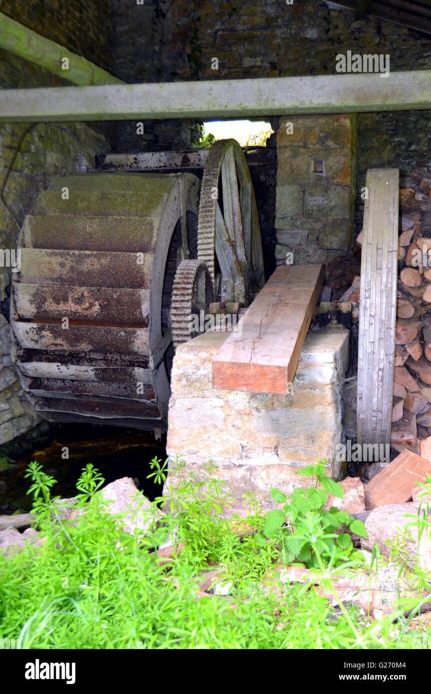 Old wheel with wooden water and fer dans an old barn. Stock Photo