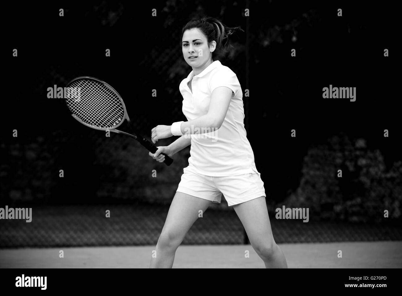 Pretty tennis player playing on court Stock Photo