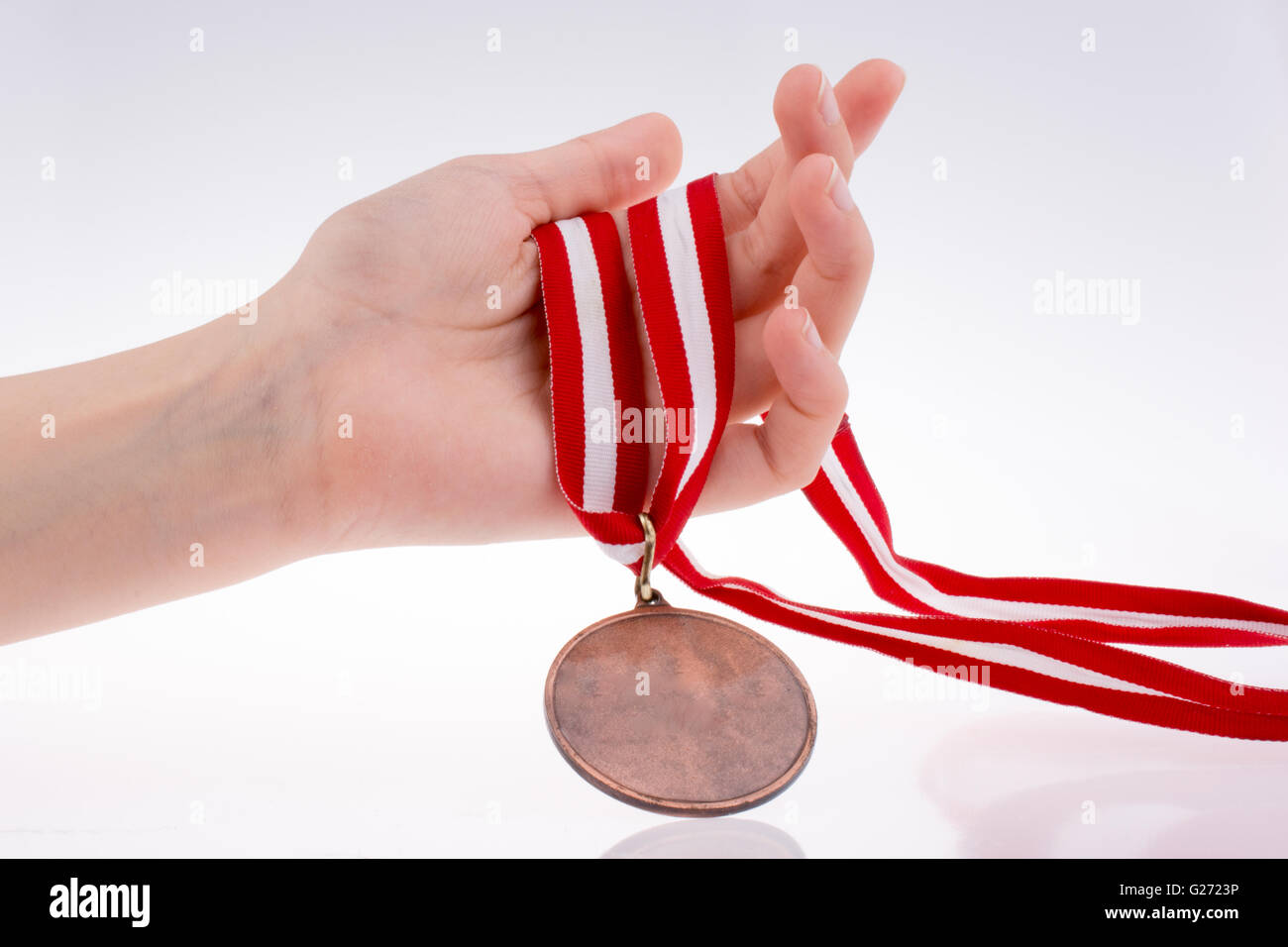 Hand holding a medal with red and white ribbon Stock Photo - Alamy