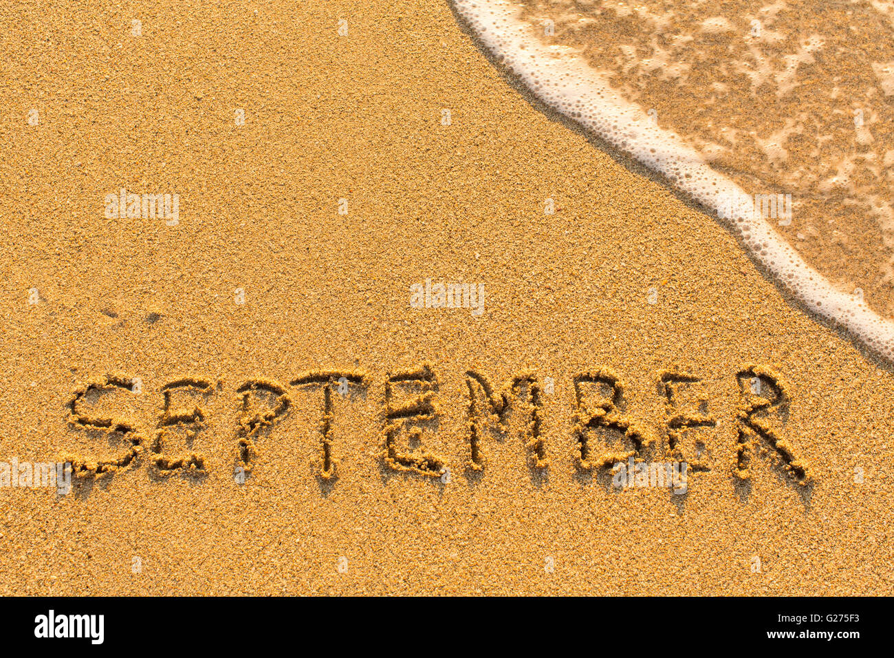 September - written by hand on a golden beach sand Stock Photo - Alamy