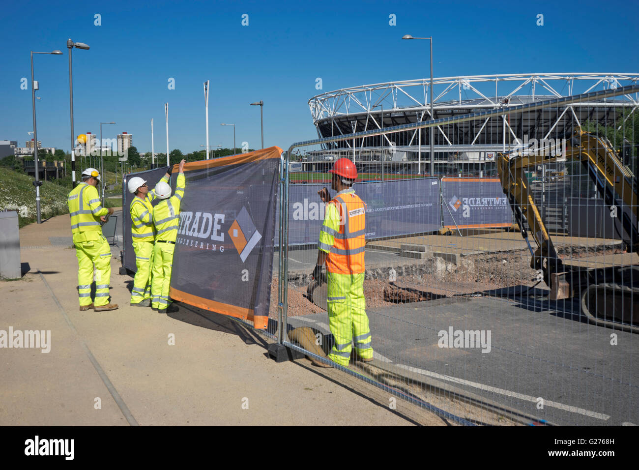 Workers at the London Olympic stadium with West Ham United football club hoardings already in place ahead of the Premier League Stock Photo