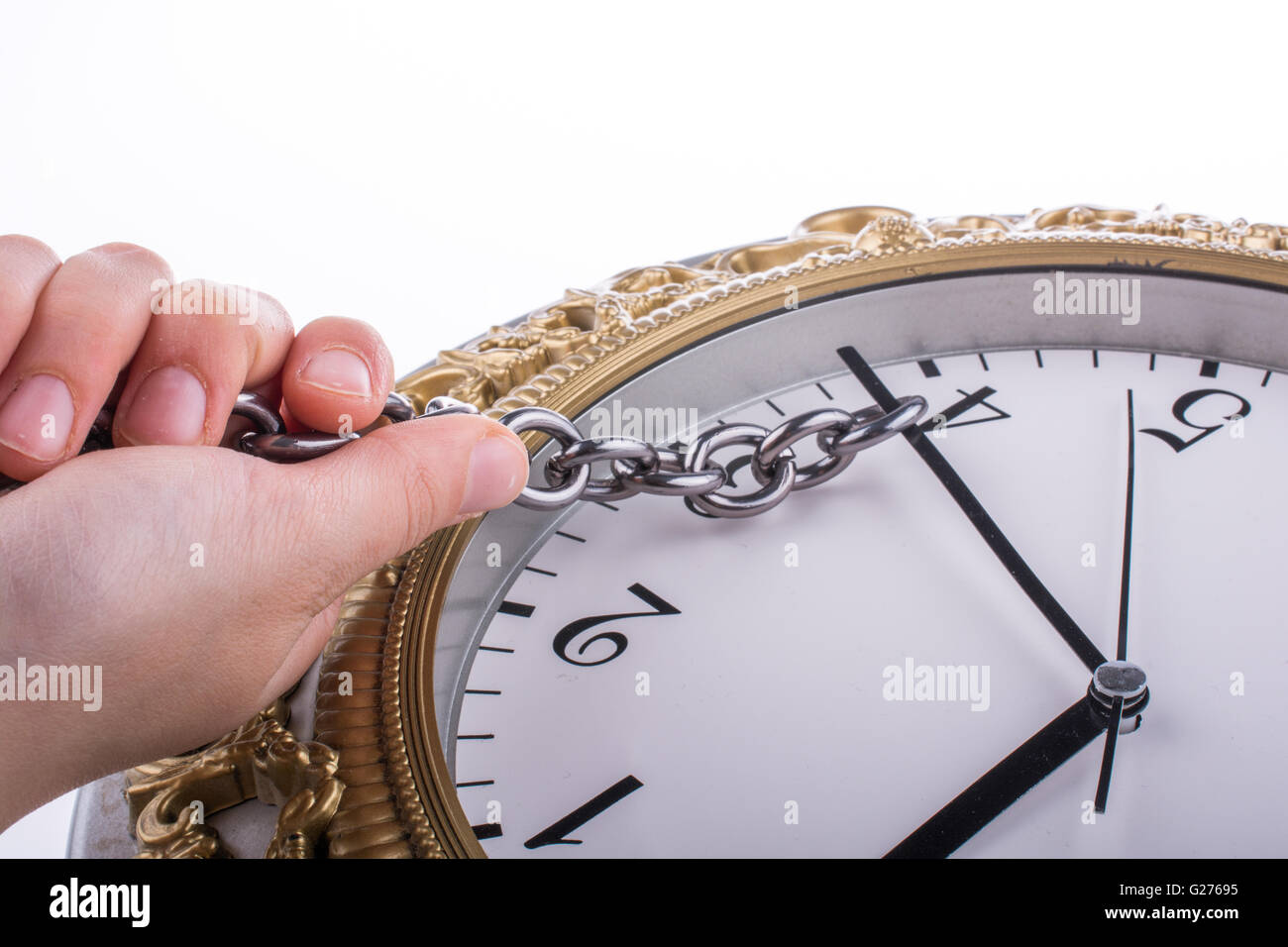 chain tied to minute hand of a clock and pulled on a white background ...