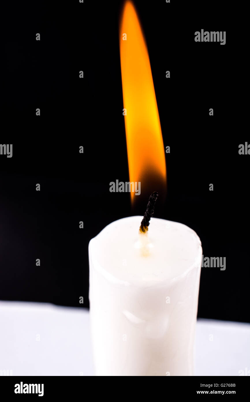 burning white candle on a black background Stock Photo - Alamy