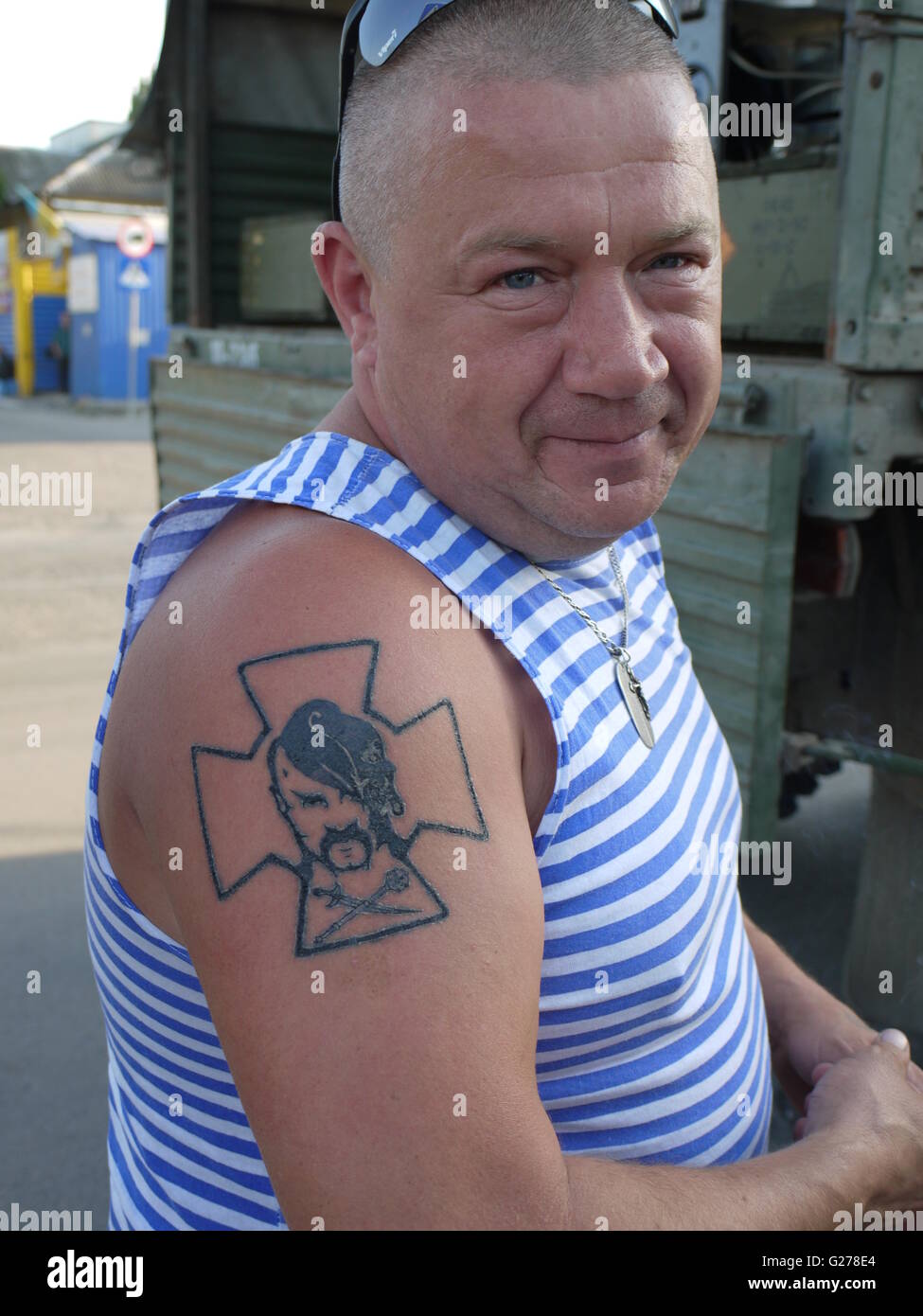 A ukrainian soldier who fight against separatists on the front line in Donbass with patriotic tattoo of cossack face Stock Photo