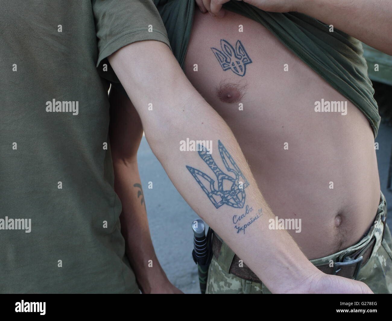Ukrainians soldiers who fight against separatists show patriotic tattoos on the front line in Donbass Stock Photo