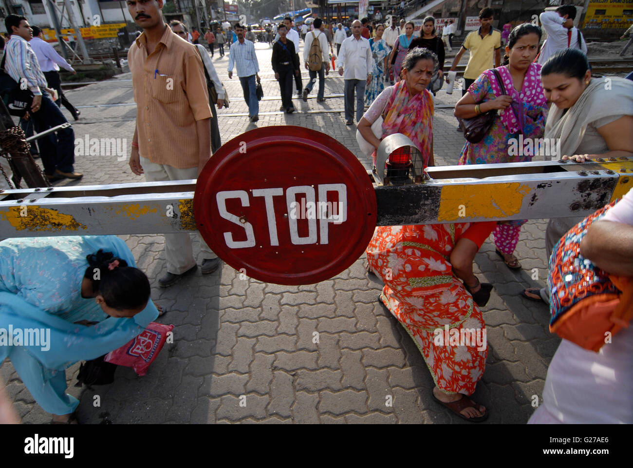 INDIA Mumbai Bombay, pedestrians cross a closed railway barrier of city train line of western railways, daily crowd disorder Stock Photo