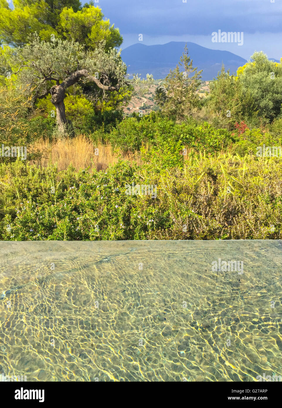 water in a marble pool with a view of the Greek countryside and mountains beyond Stock Photo
