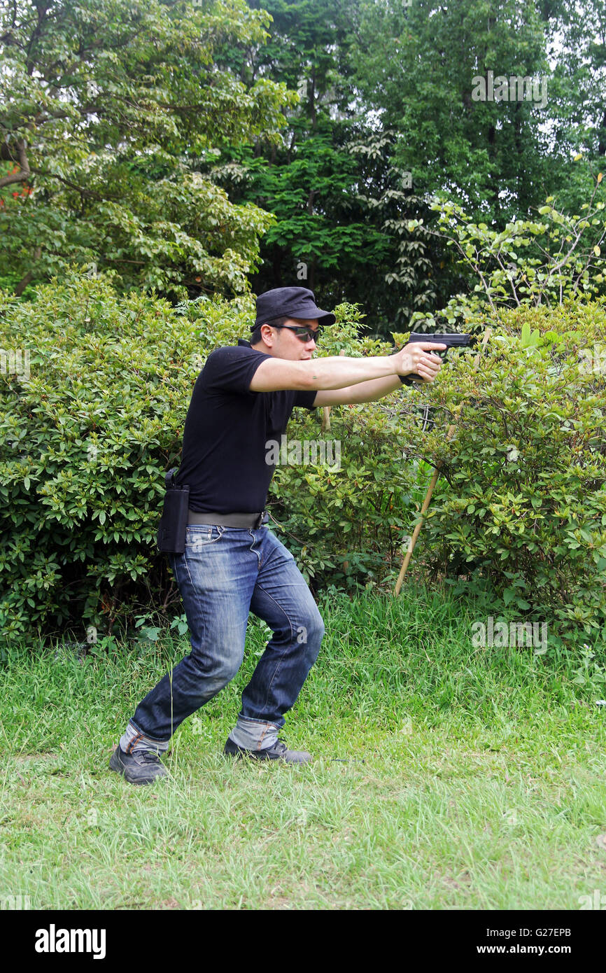 a man shooting a gun on the move ipsc ipda Stock Photo