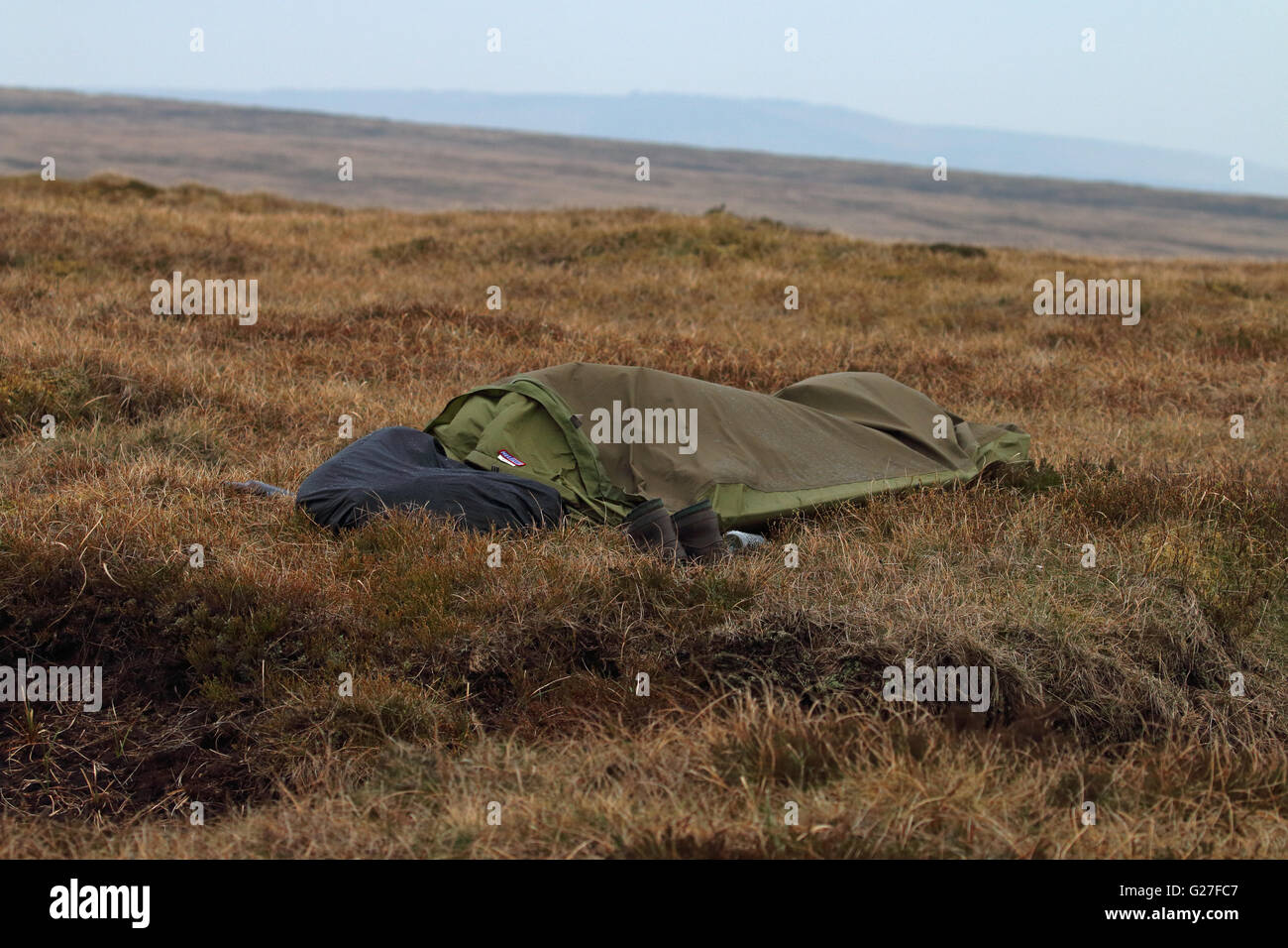 Someone wild camping under a bivvy bag asleep on the bleaklow moors above glossop Stock Photo