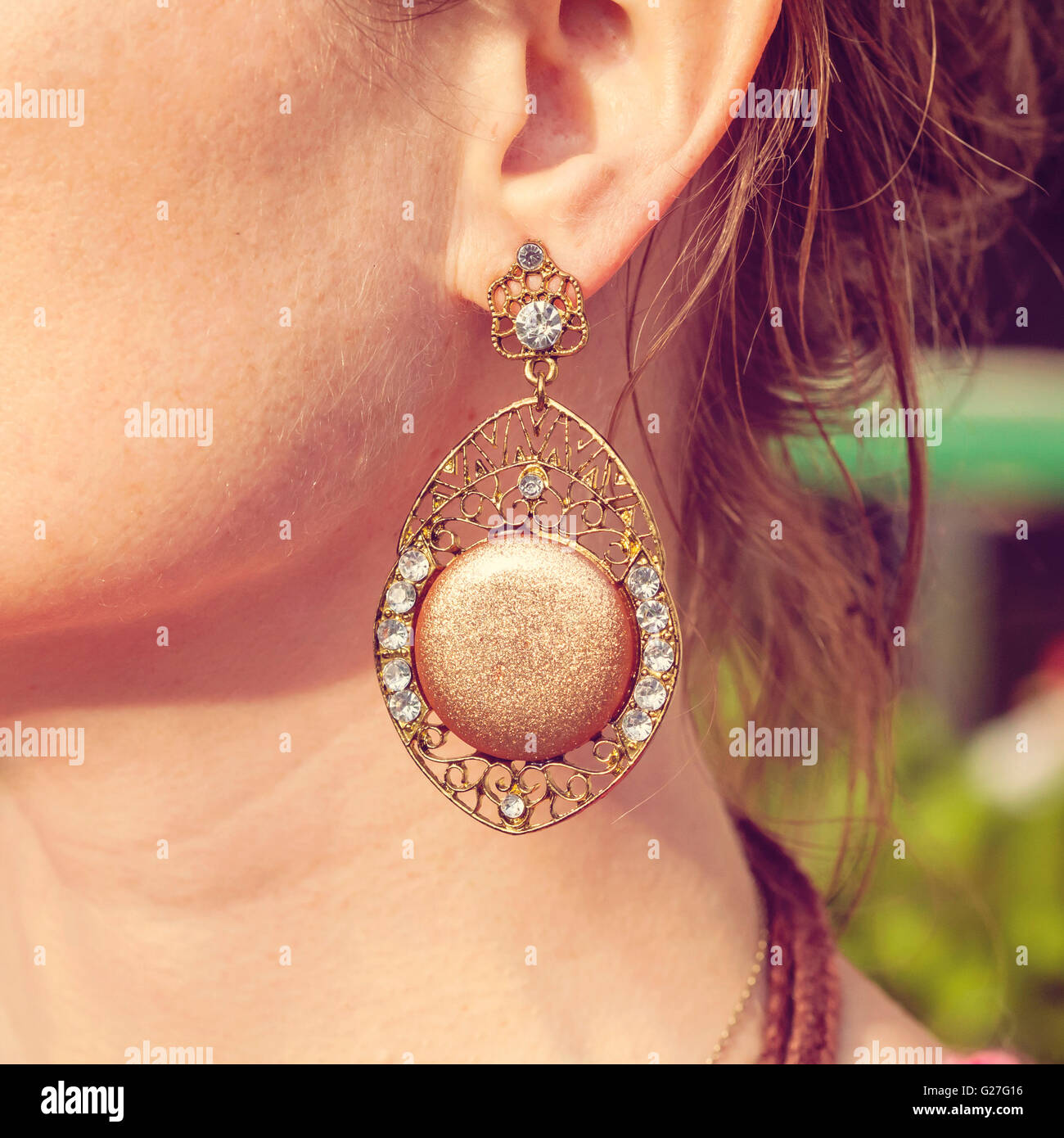 Beautiful earring in boho style on female ear Stock Photo