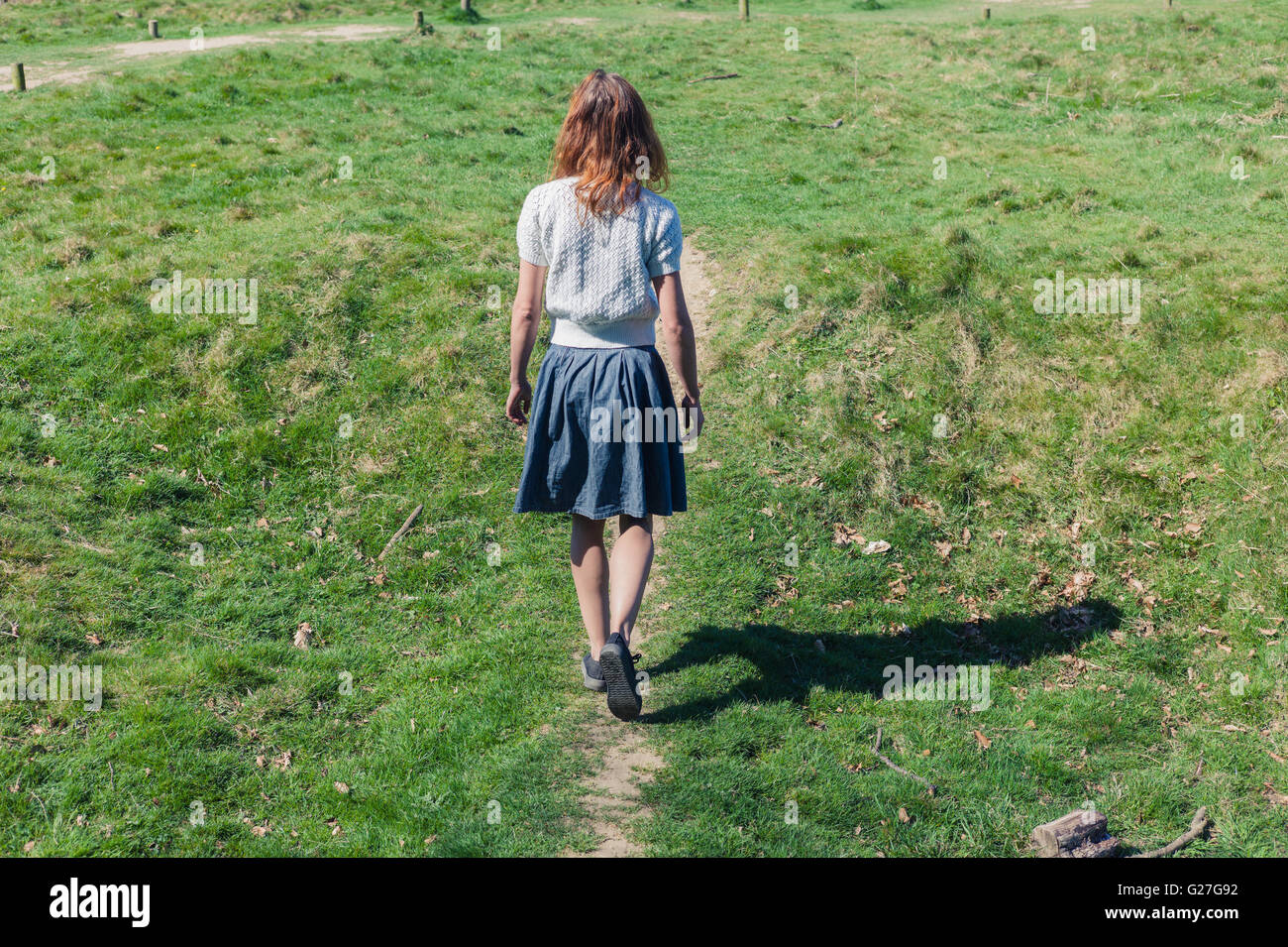 A young woman is walking in the countryside Stock Photo - Alamy