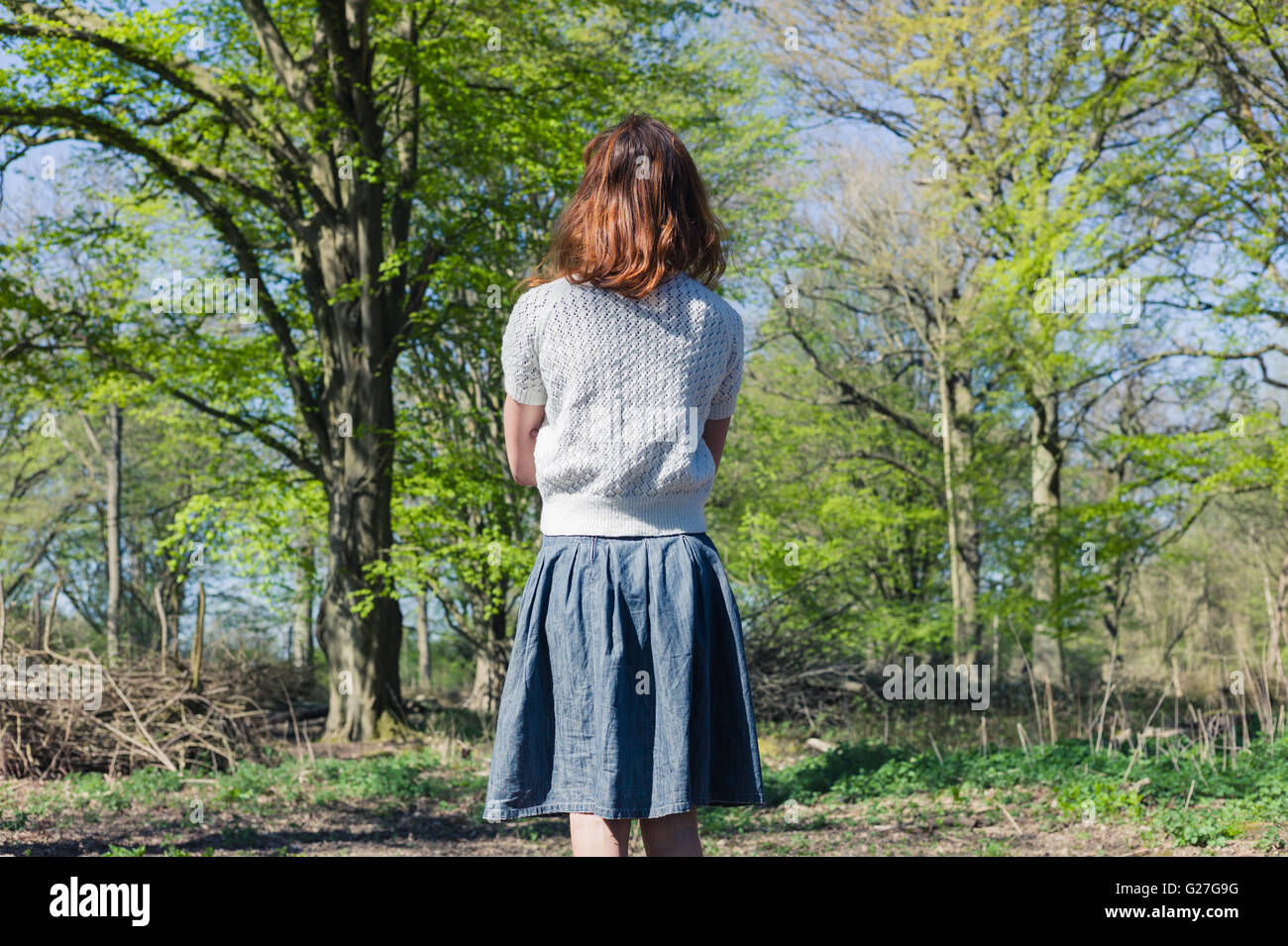 A young woman is standing in a forest Stock Photo - Alamy