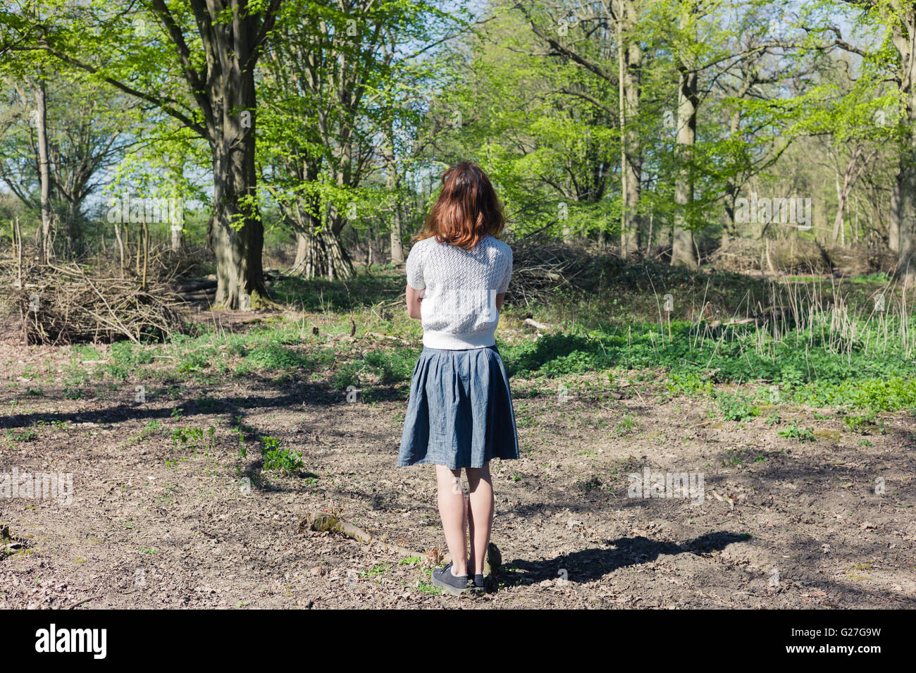 A young woman is standing in a forest Stock Photo - Alamy