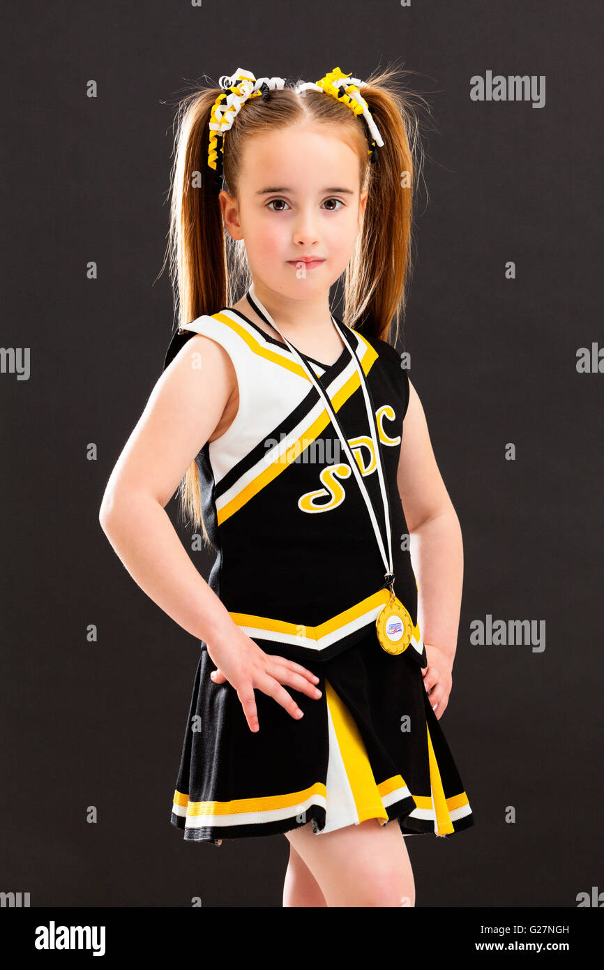 A young Caucasian girl dressed in a Cheer Dance outfit and wearing a medal around her neck. England, UK. Stock Photo