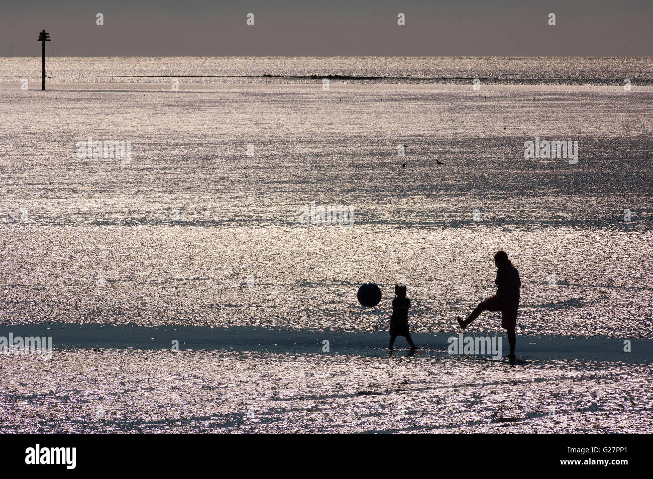 Man and child play with ball on the beach at Morecambe Lancashire England Stock Photo
