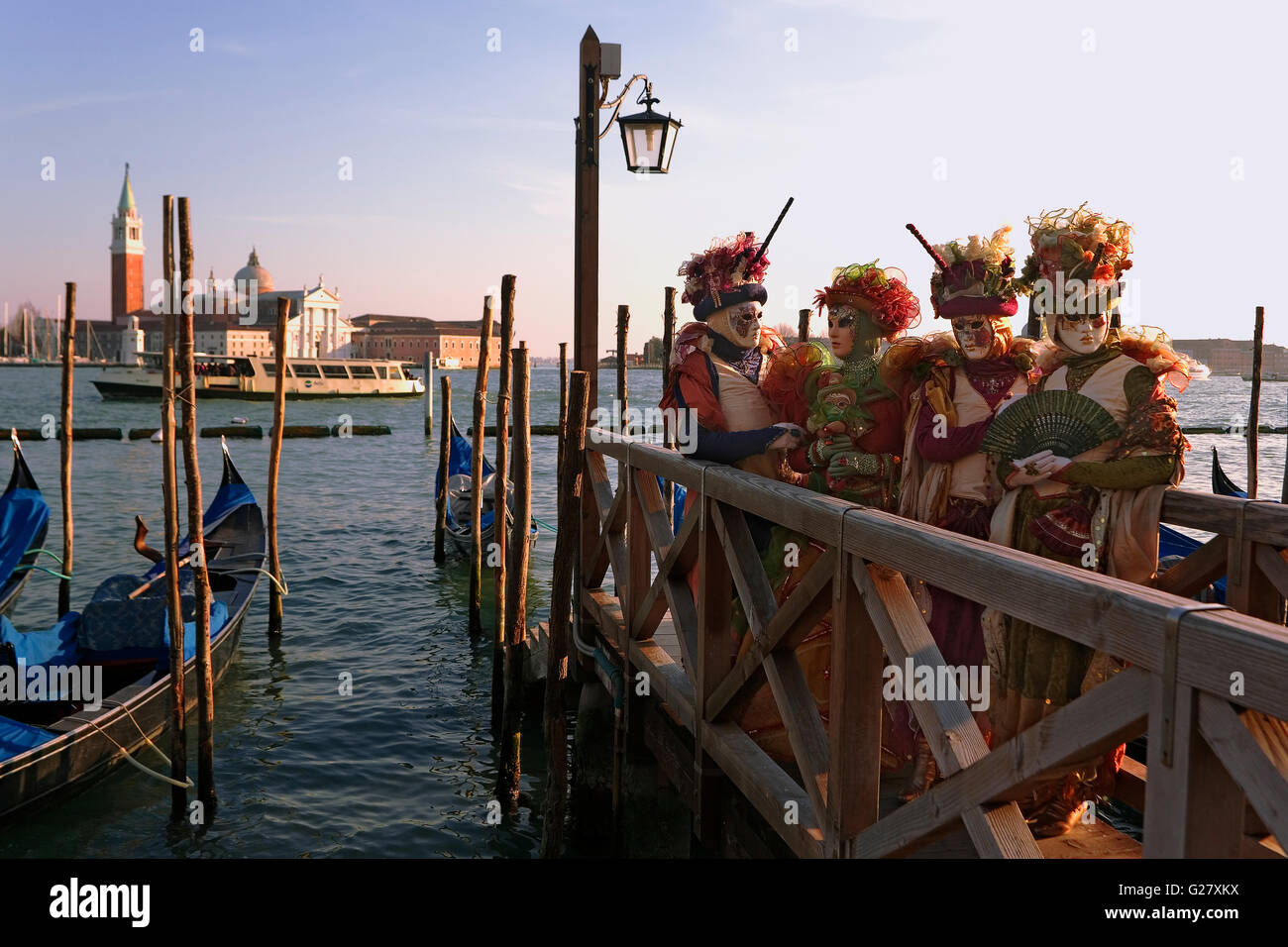 Venice Carnival: San Marco, Venice, Italy.  Carnival revellers pose in front of the Basin of St Mark, with the church of San Giorgio Maggiore beyond Stock Photo