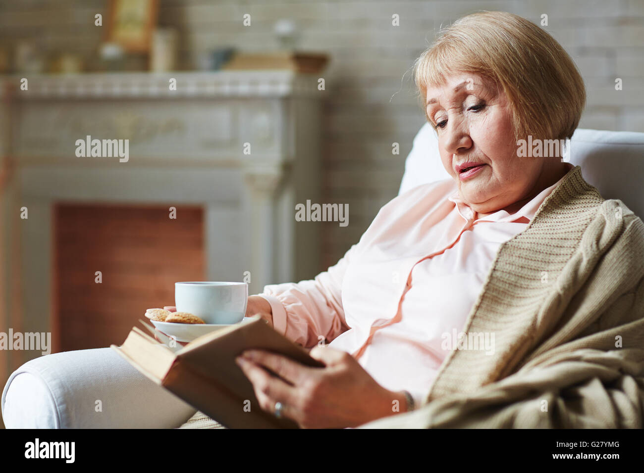 Reading in armchair Stock Photo Alamy