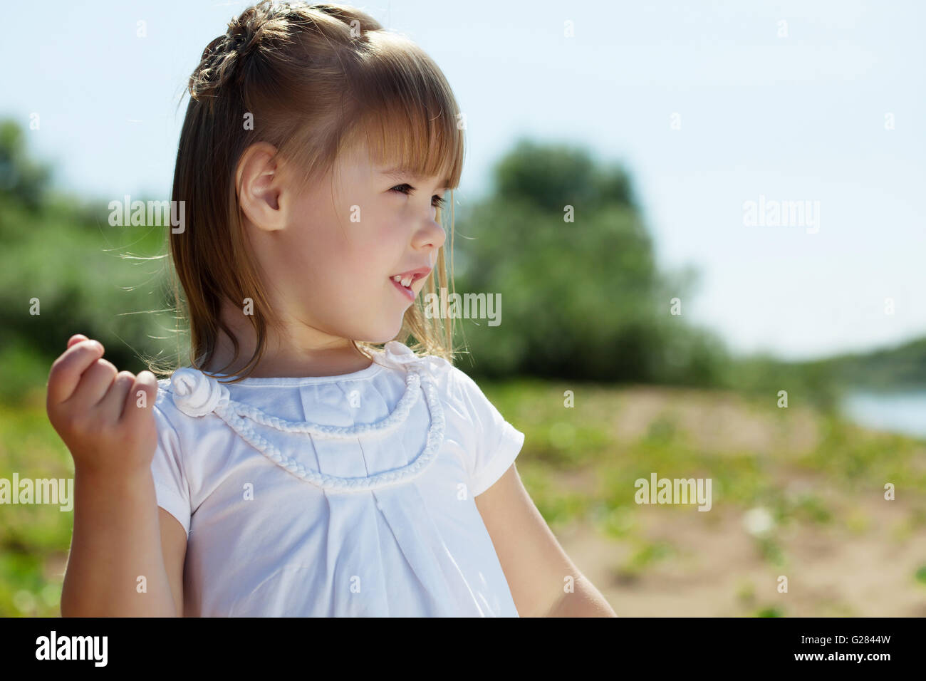 Portrait of merry little girl posing in park Stock Photo - Alamy