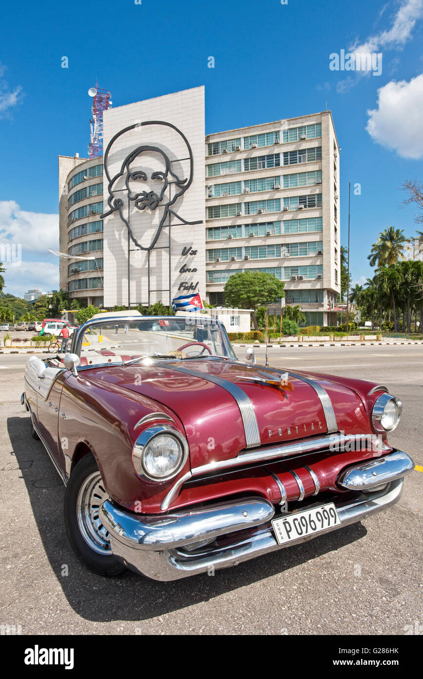 1955 Pontiac Star Chief parked on Revolution Square in front of the Image of revolutionary guerrilla fighter Camilo Cienfuegos. Stock Photo