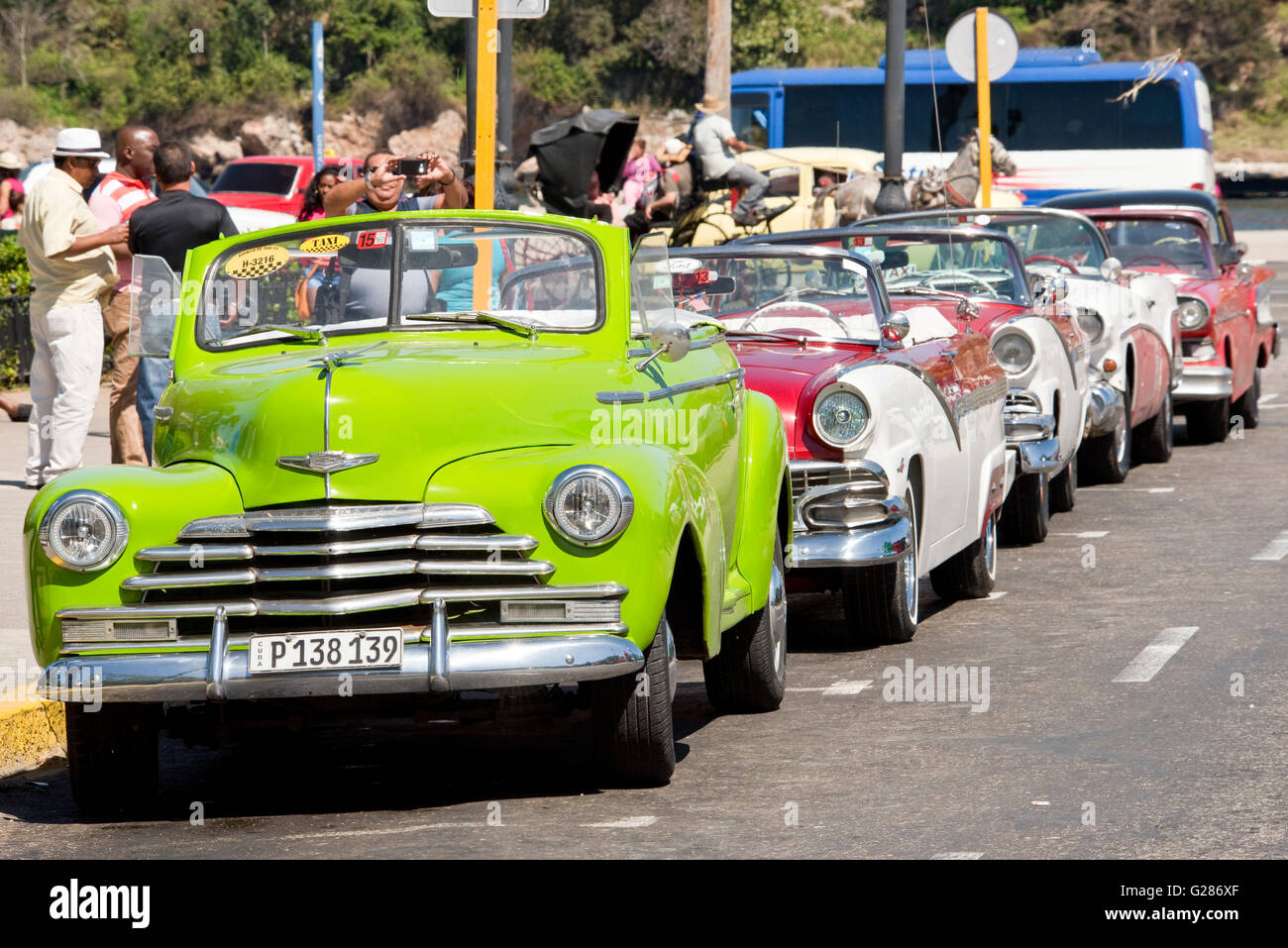 A row of old American cars lined up in Havana with a 1948 Chevrolet Fleetmaster in the foreground. Stock Photo
