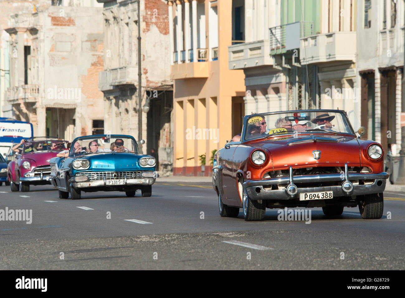 A 1958 Pontiac Super Chief (Blue Car) and a 1953 Mercury Monterey (Red/Brown Car) along the Malecón in Havana, Cuba. Stock Photo