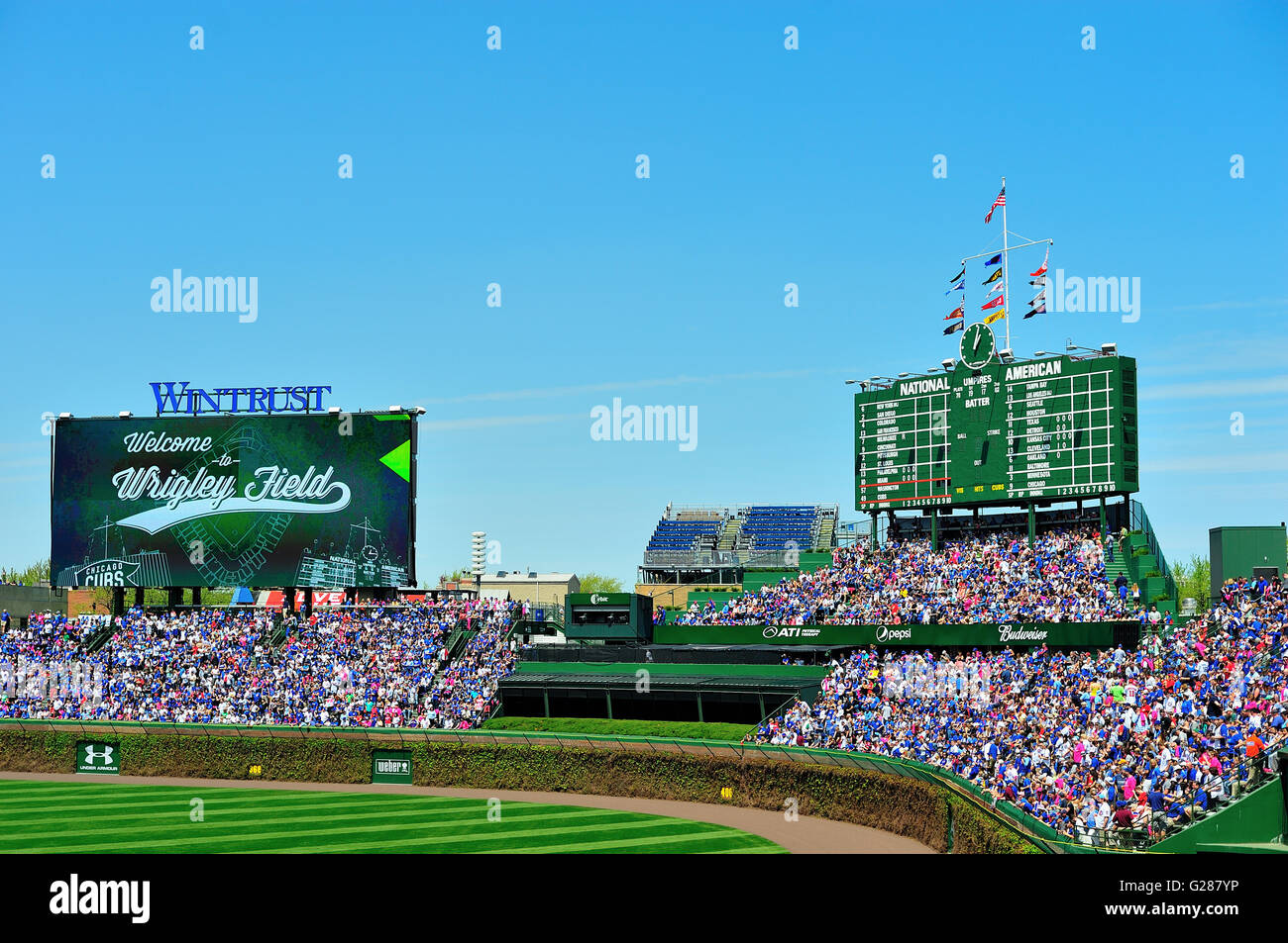 A study in contrasts at Chicago's Wrigley Field, home of the Chicago Cubs, is evident above the venerable bleacher seats. Chicago, Illinois, USA. Stock Photo