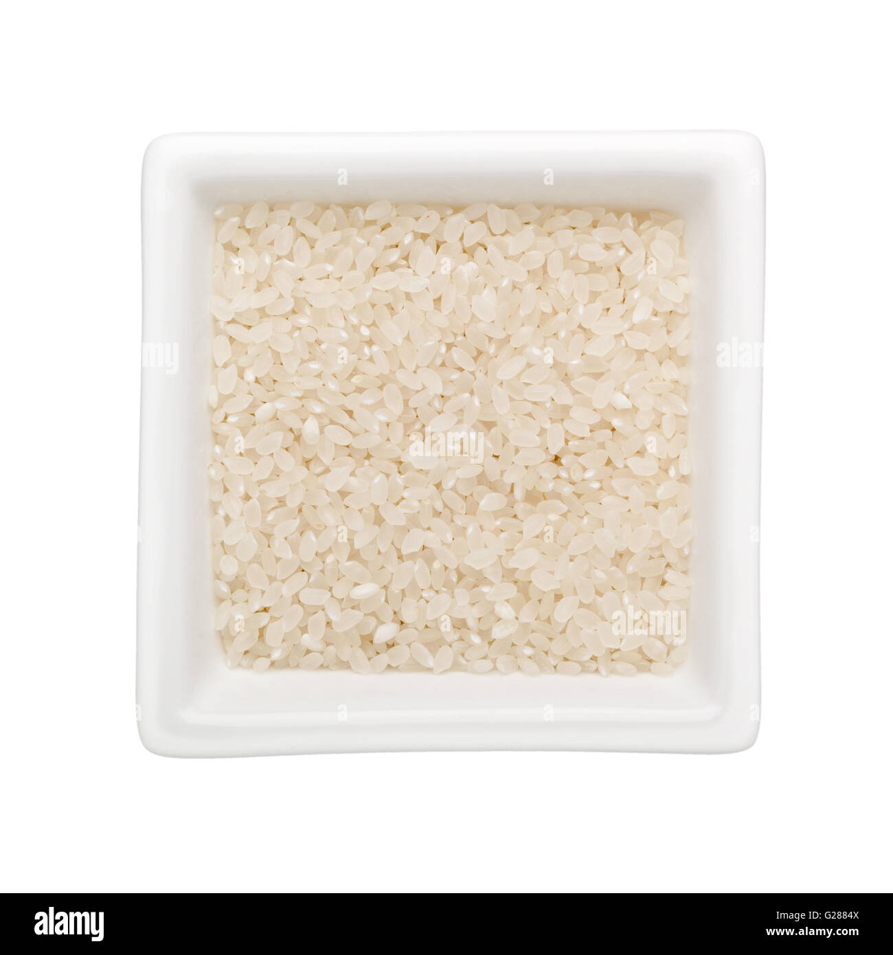 Short grain rice in a square bowl isolated on white background Stock Photo