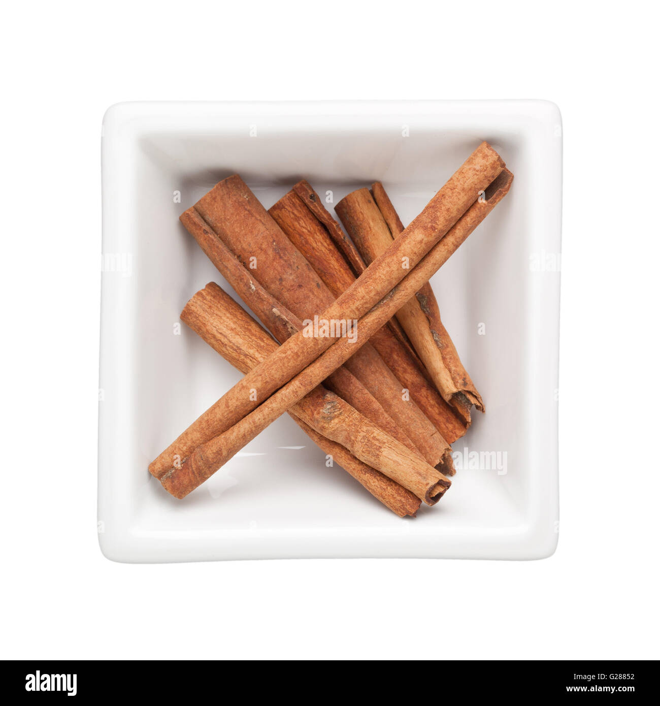 Cinnamon bark in a square bowl isolated on white background Stock Photo