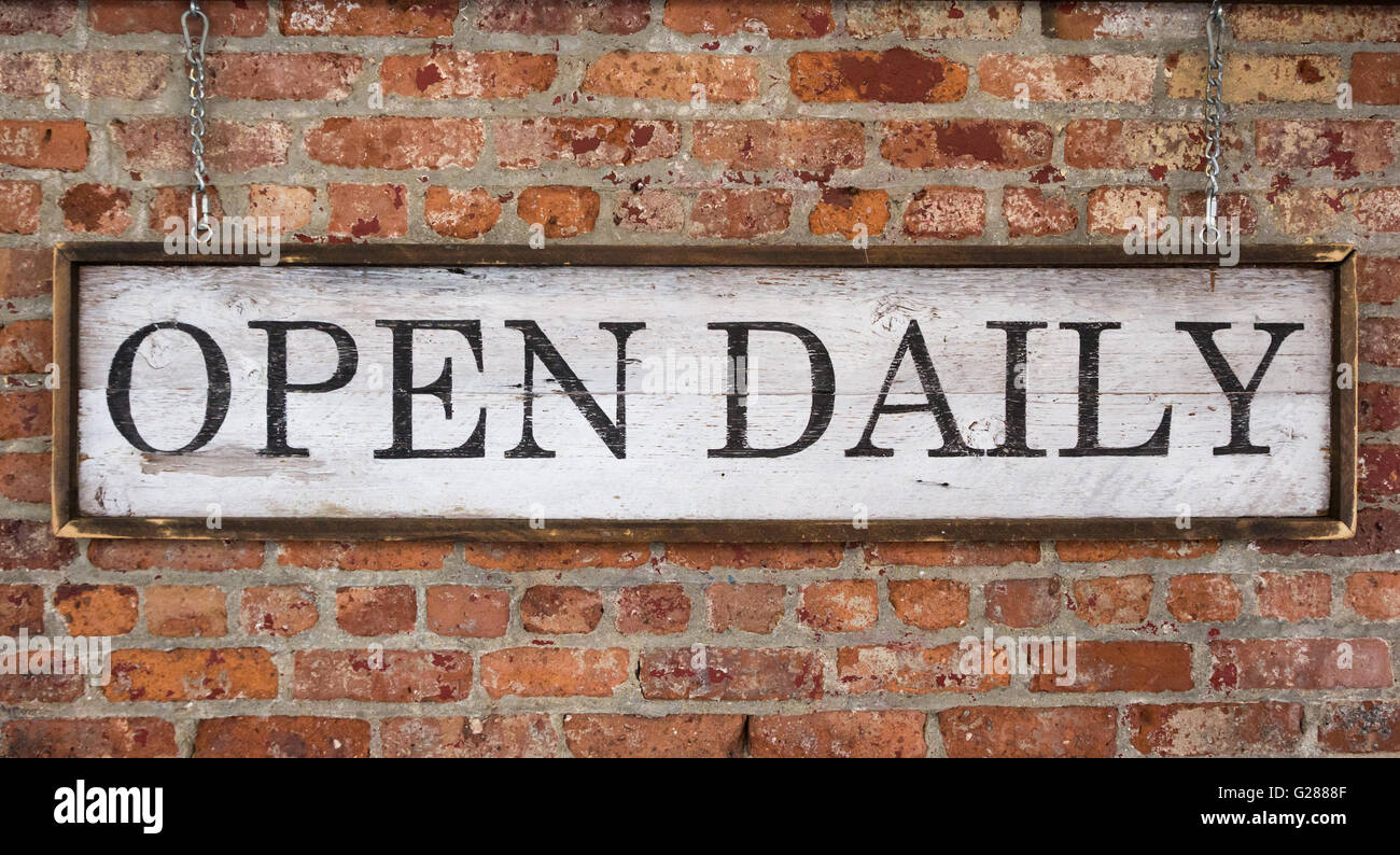 Wooden sign with text open daily on a vintage brick wall Stock Photo ...