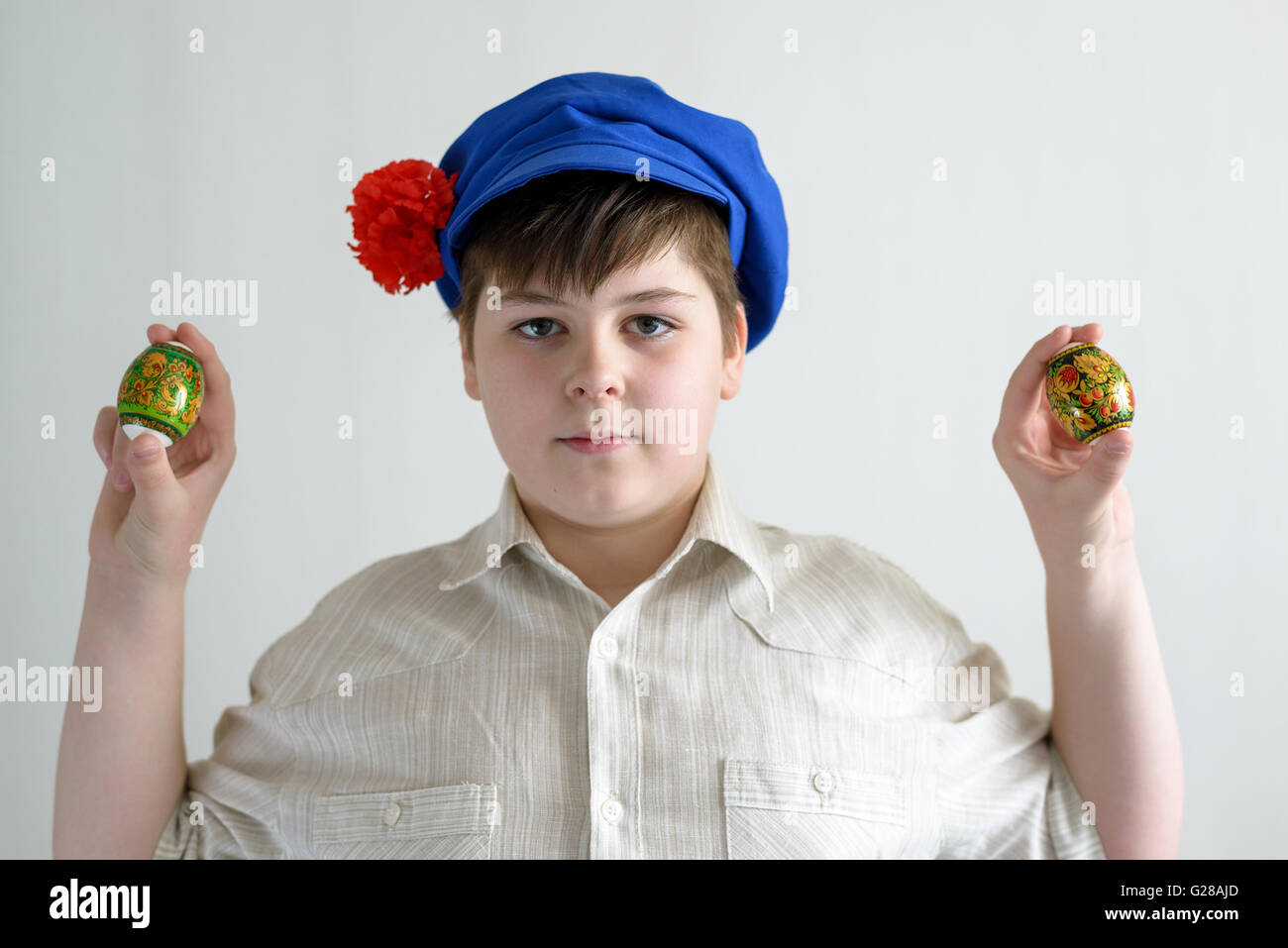 boy in Russian national cap with cloves holding easter eggs Stock Photo