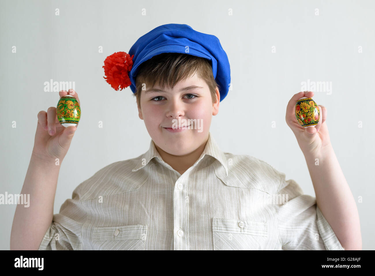 boy in Russian national cap with cloves holding easter eggs Stock Photo