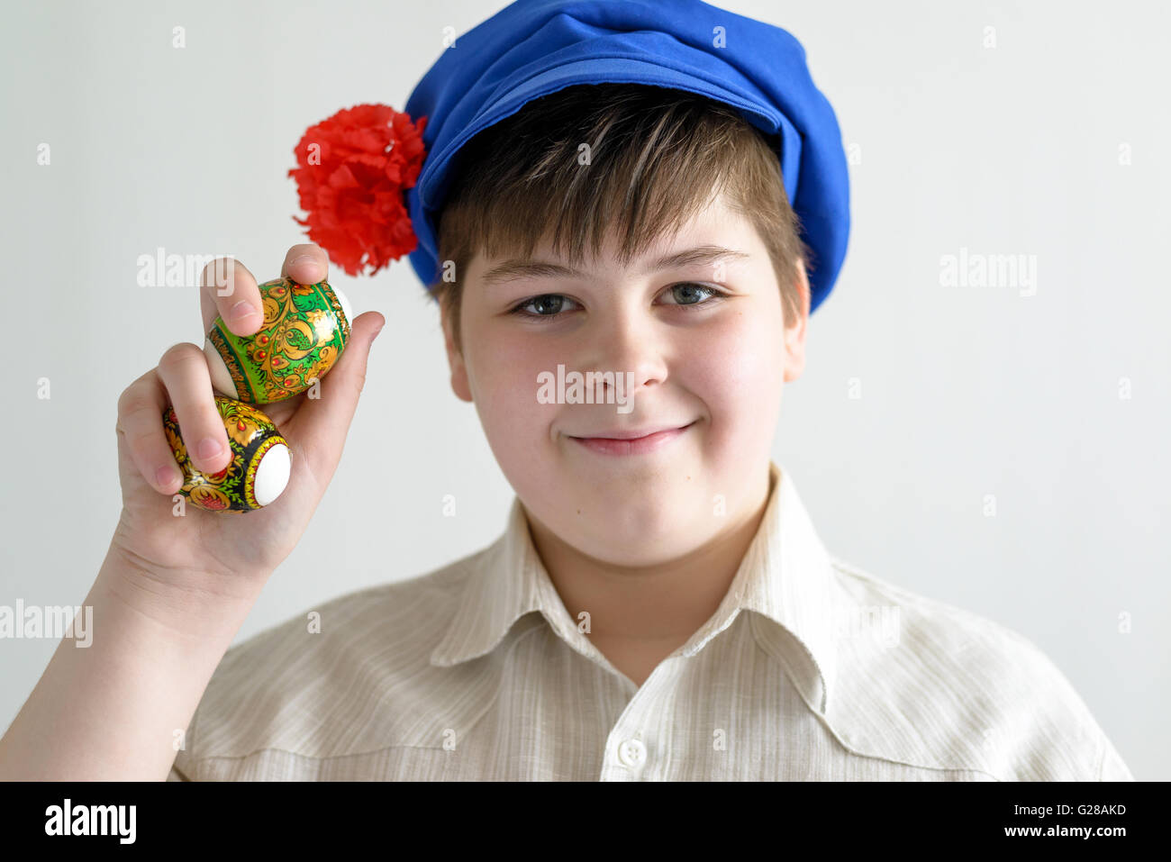 boy in Russian national cap with cloves holding easter eggs Stock Photo