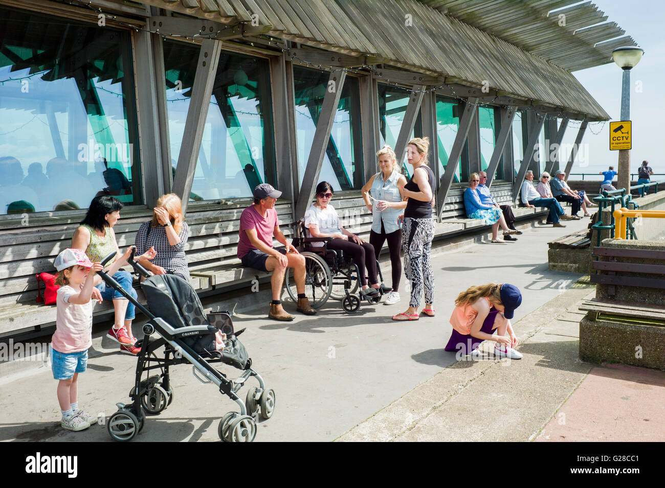 People and children enjoying the sunshine on Deal Pier Stock Photo