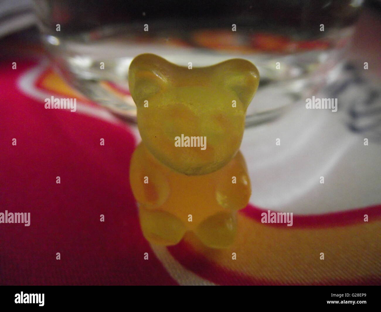 Yellow gummy bear on red tablecoth Stock Photo