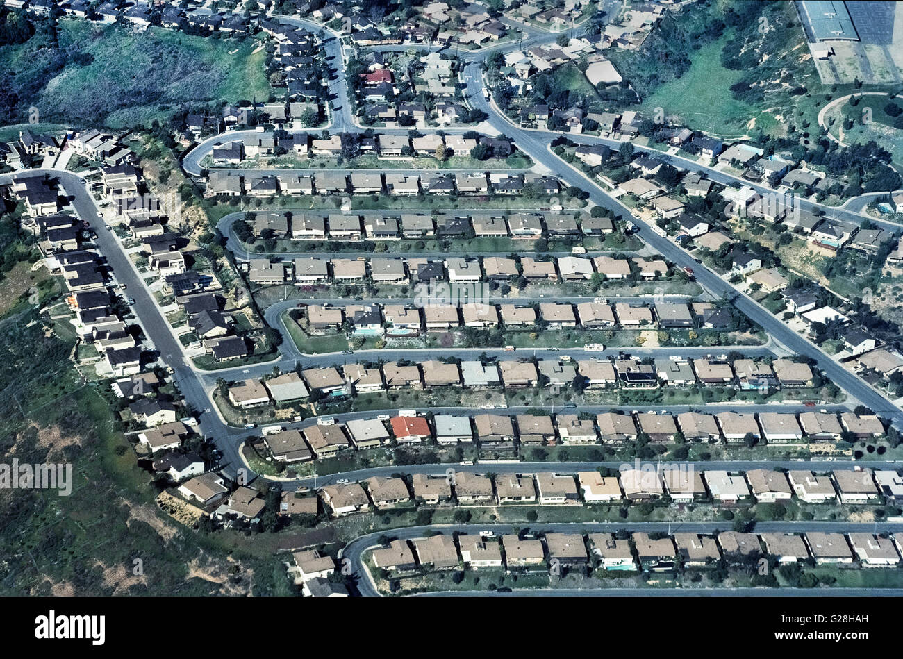 An aerial view shows side-by-side homes that are crammed into this housing development among foothills in San Diego County in Southern California, USA. Such jam-packed suburban neighborhoods are common there because of the popularity of that southernmost county in the state and the area's exceptionally pleasant weather. Stock Photo