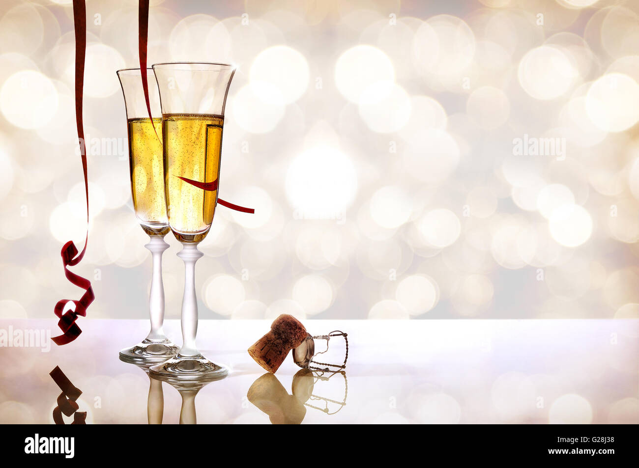 Two glasses of sparkling white wine on white methacrylate table with ...