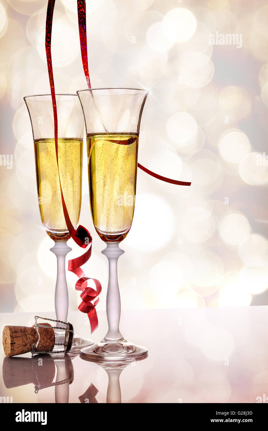 Two glasses of sparkling white wine on white methacrylate table with ...