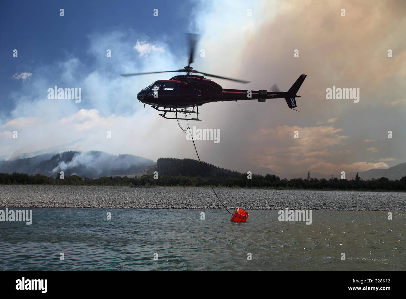 New Zealand helicopter fills a monsoon bucket in a river at a large blaze  near Blenheim, Marlborough Stock Photo - Alamy