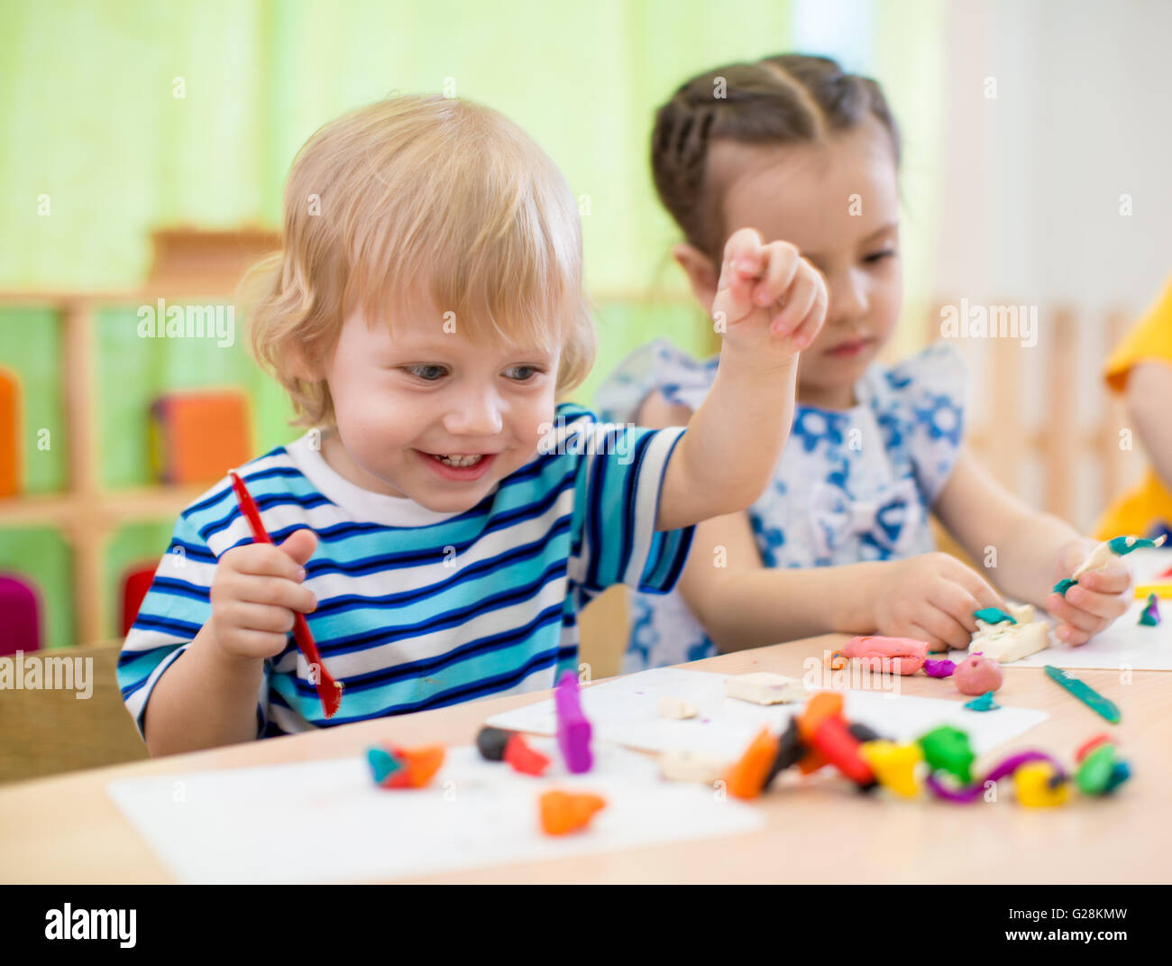 Happy children doing arts and crafts. Kids in kindergarten. Stock Photo