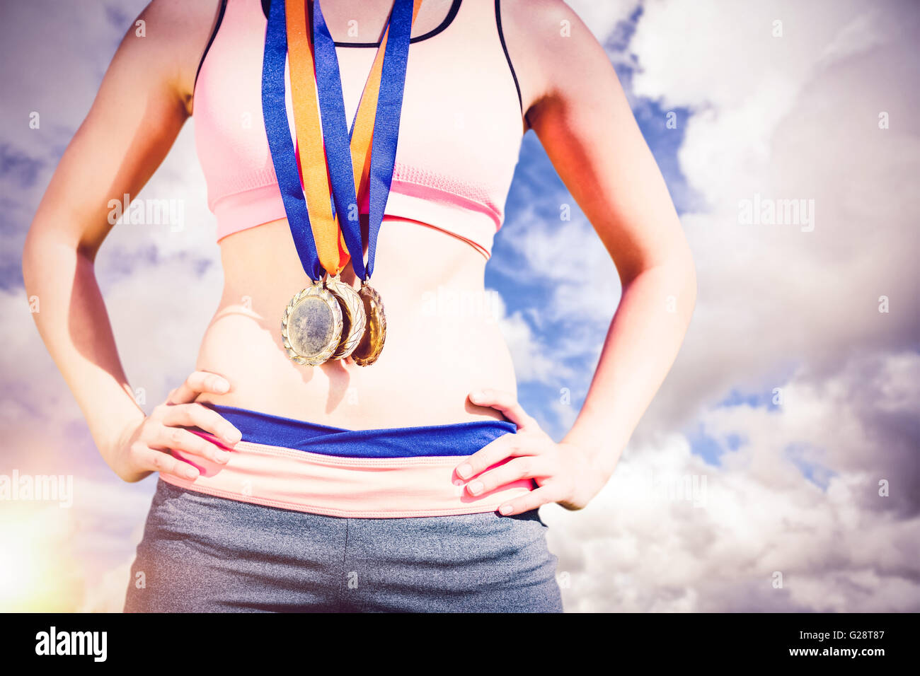 Composite image of portrait of sporty woman chest holding medals Stock Photo