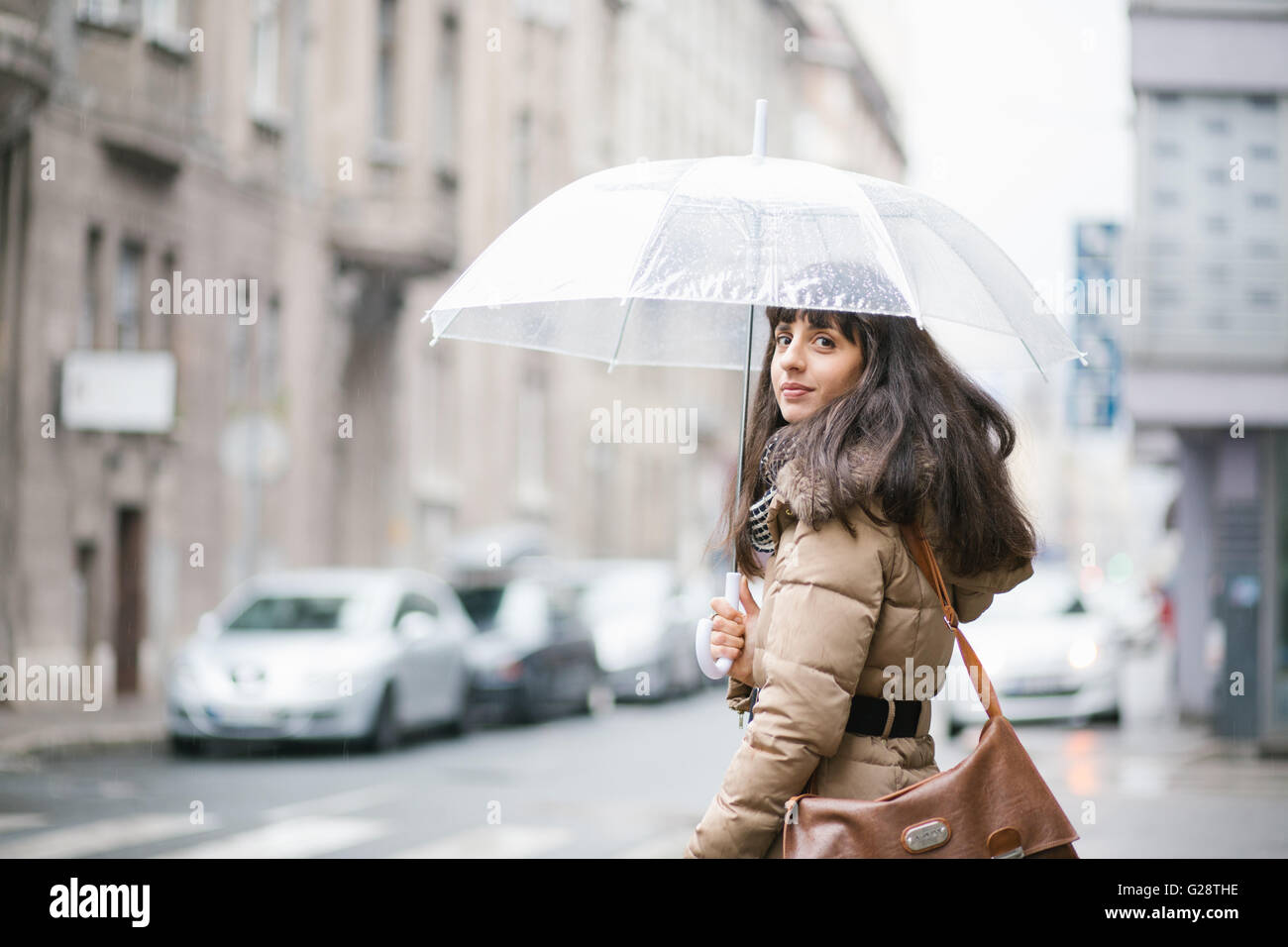 Young woman on the street holding transparent umbrella Stock Photo - Alamy
