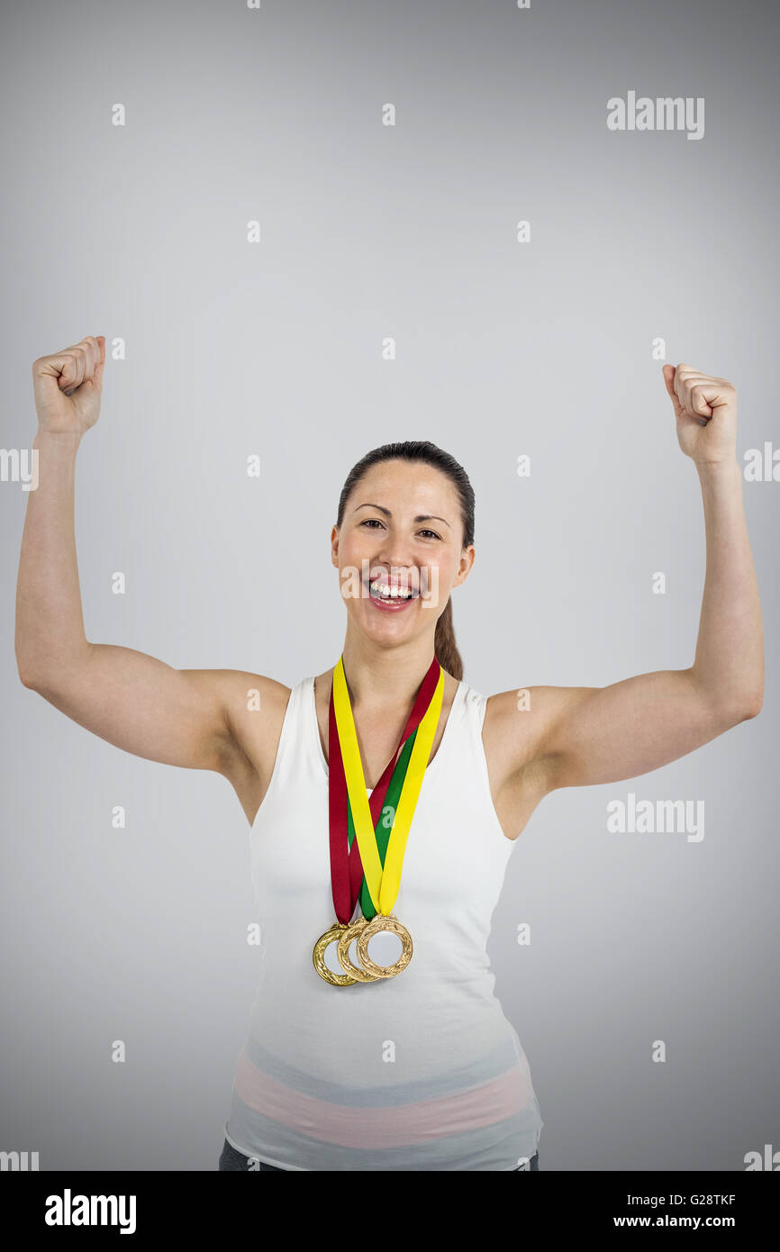 Composite image of female athlete posing with gold medal after victory Stock Photo
