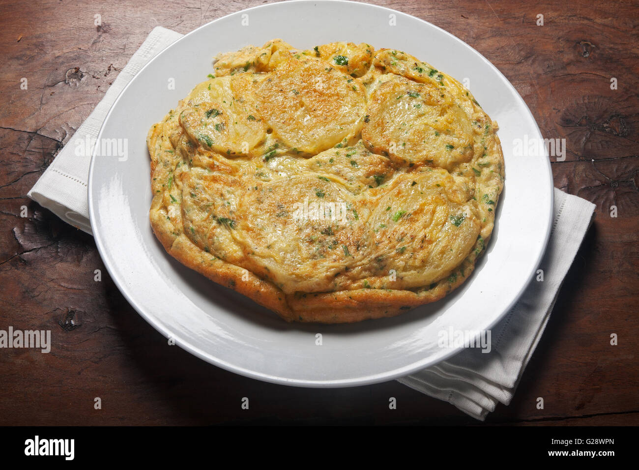 Potatoes omelette on a wooden table Stock Photo